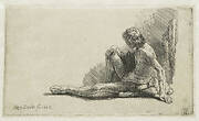 Nude man seated on the ground with one leg extended