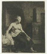 Woman sitting half dressed beside a stove